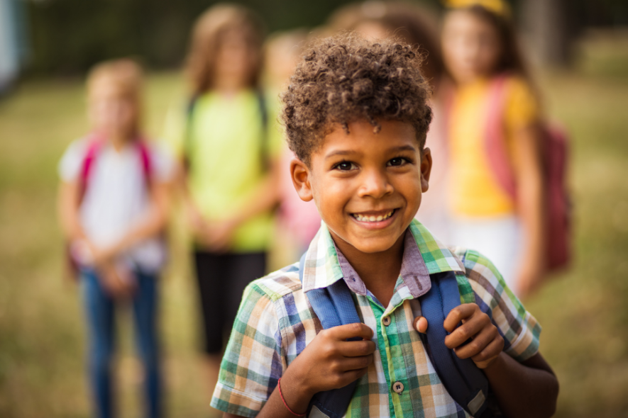 young boy holding pack pack