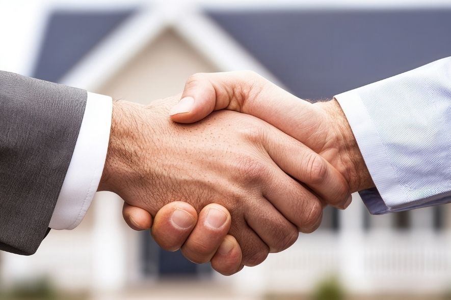 handshake in front of a home